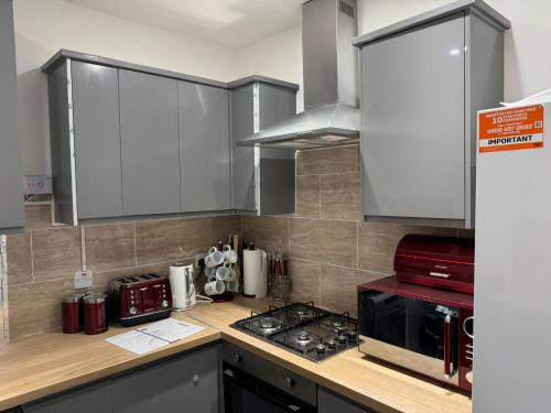 a kitchen with a stove top oven next to a microwave at Chic Above Store in Tredegar