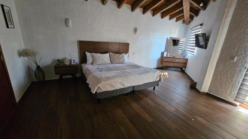 a bedroom with a bed and a wooden floor at Loft 49 Valquirico in Santeagueda