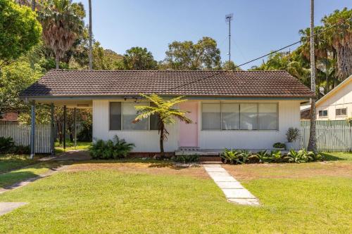 a house with a palm tree in the yard at Lizzie Shack in Elizabeth Beach