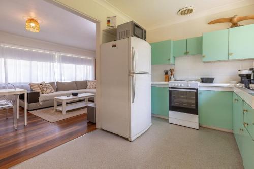 a kitchen with a refrigerator and a living room at Lizzie Shack in Elizabeth Beach