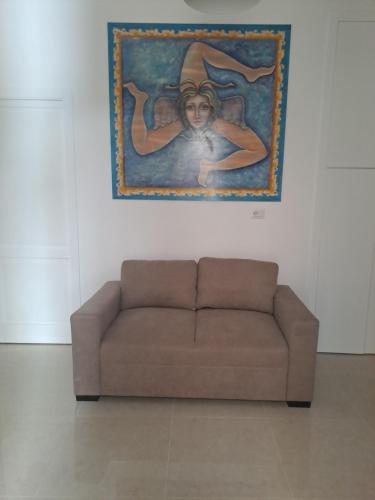 eine Couch in einem Zimmer mit einem Gemälde an der Wand in der Unterkunft ORTIGIA LUXURIs DOMUs in Syrakus