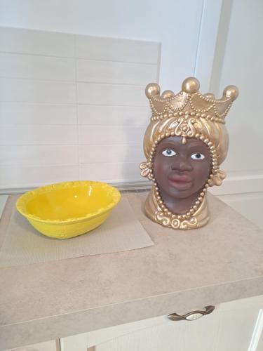 ein Kopf mit Krone und eine Schale auf einer Theke in der Unterkunft ORTIGIA LUXURIs DOMUs in Syrakus