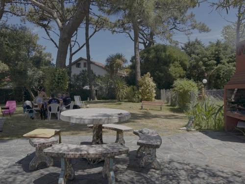 Ein Tisch und Bänke in einem Park, an denen Menschen sitzen. in der Unterkunft La casita en la playa in Villa Gesell