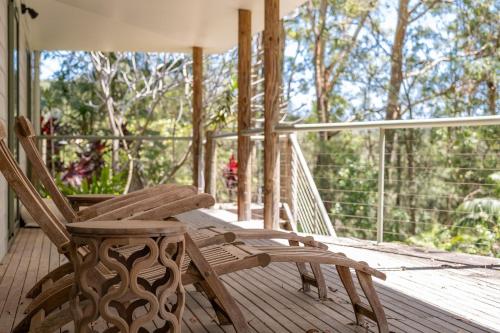 a pair of rocking chairs on a porch at Karingal just minutes from Blueys Beach in Charlotte Bay