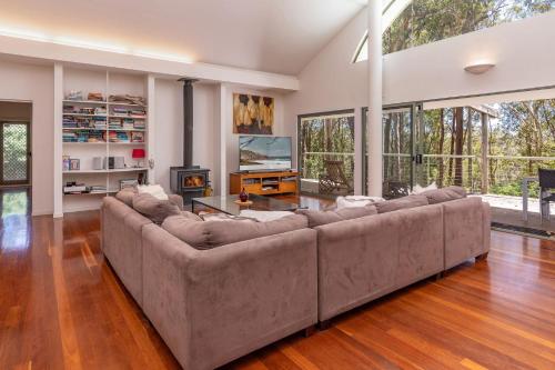 a large living room with a couch and a fireplace at Karingal just minutes from Blueys Beach in Charlotte Bay