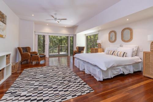 um quarto com uma cama grande e uma lareira em Karingal just minutes from Blueys Beach em Charlotte Bay