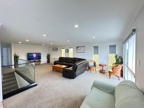 a living room with a couch and a flat screen tv at Natural Geothermal Hot Spring Retreat Rotorua in Rotorua