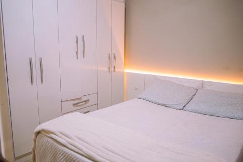 een slaapkamer met een bed en een witte kast bij Apartamento 1 Quarto Canasvieiras in Florianópolis