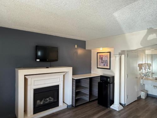 a living room with a fireplace and a tv on a wall at Express Inn-Rahway in Rahway