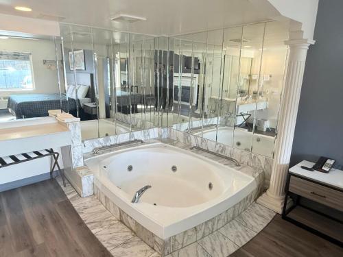 a large bathroom with a tub and a bedroom at Express Inn-Rahway in Rahway