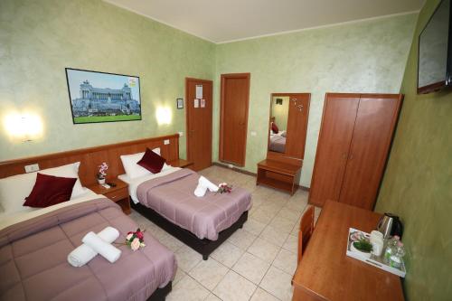ein Hotelzimmer mit zwei Betten und einem Spiegel in der Unterkunft Dreamland Guesthouse in Rom