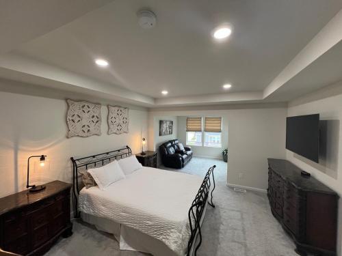 une chambre avec un lit et une télévision à écran plat dans l'établissement Kensington Kickback QUICK Access to Ann Arbor, 