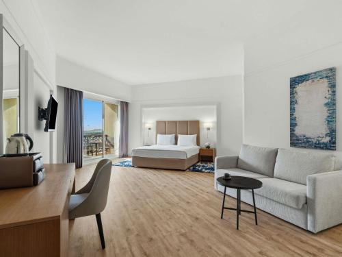 a hotel room with a bed and a couch at Rixos Bab Al Bahr - Ultra All Inclusive in Ras al Khaimah