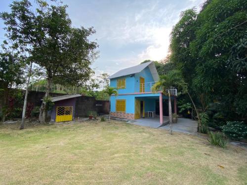 una casa blu e gialla con cortile di Retiro Esperança a Santa Isabel do Pará