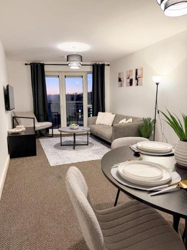 a living room with a table and chairs and a couch at Stylish 2-Bed Apartment in Central Bolton in Bolton