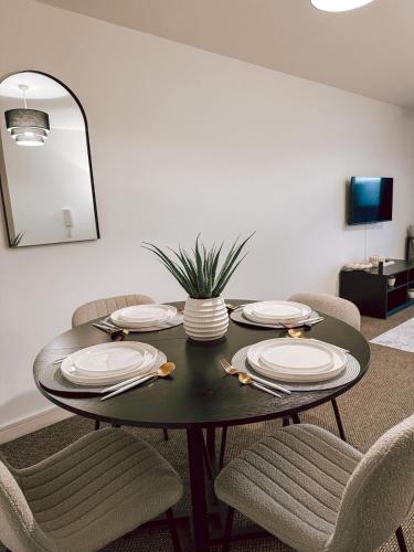 a dining room with a table with plates and chairs at Stylish 2-Bed Apartment in Central Bolton in Bolton