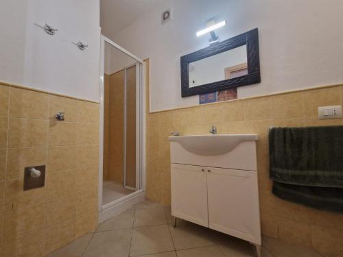 a bathroom with a sink and a shower and a mirror at T2 Djadsal Bloco Laranja Perto da Praia e Centro in Santa Maria