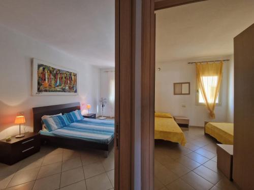 a bedroom with two beds and a door to a room at T2 Djadsal Bloco Laranja Perto da Praia e Centro in Santa Maria