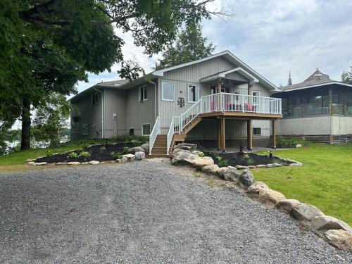 a large house with a porch and a driveway at Tait Lake Retreat - Luxury Lakeside Home in Turriff