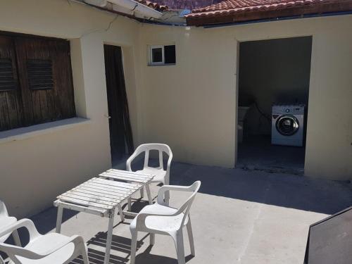 un patio con tavolo, sedie e lavatrice di Chalet en Mogotes a Mar del Plata