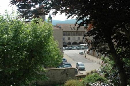a city street with cars parked in a parking lot at Le Clos de l'Abbaye in Cluny