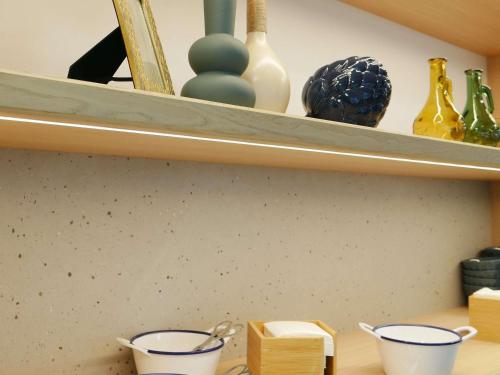 ヴィシーにあるMercure Vichyの2つのカップと花瓶が置かれた棚