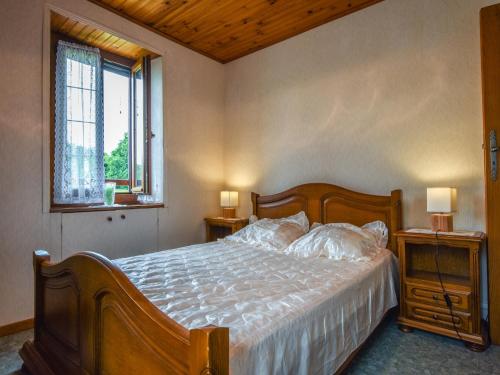 a bedroom with a bed with two night stands and two windows at Padirac Countryside Charm in Padirac
