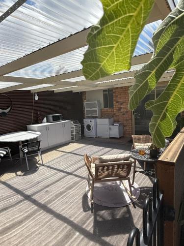 un patio con techo, mesa y sillas en Montrose holiday cottage, en Rosetta