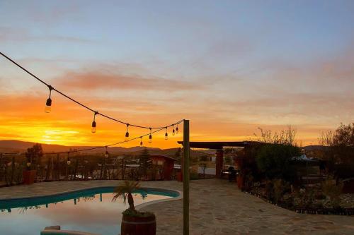 une piscine avec un coucher de soleil en arrière-plan dans l'établissement Suite Mediterranea Valle de Gpe WiFi BBQ & Pool, à Villa de Juárez
