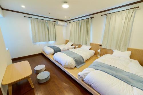 - 2 lits dans une grande chambre avec une table dans l'établissement Atami Regalo - Vacation STAY 62917v, à Atami
