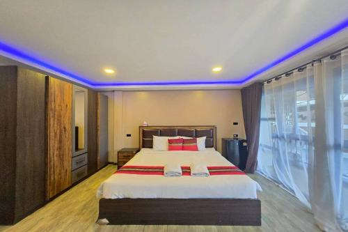 a bedroom with a large bed and a large window at Central Guesthouse Chiang Rai in Chiang Rai