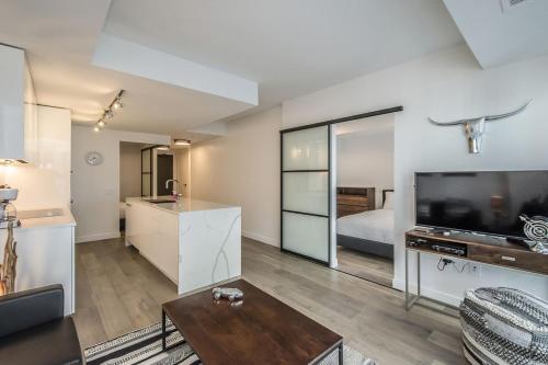 ein Wohnzimmer mit einem großen TV und einem Bett in der Unterkunft Cozy 2BR Apt with Gym and Cinema near Pier 21 in Halifax