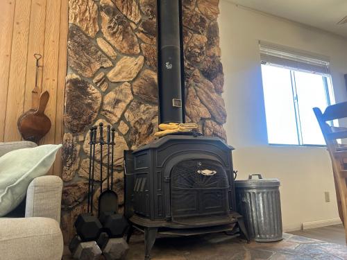 a fireplace in a living room with a stone wall at Peaceful Big Bear Cabin in Baldwin Lake