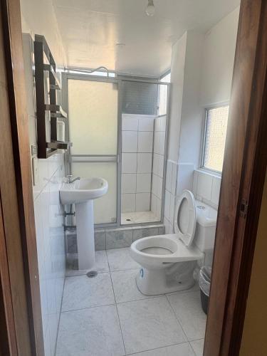 a bathroom with a toilet and a sink at Hostal Copacabanna in Baños
