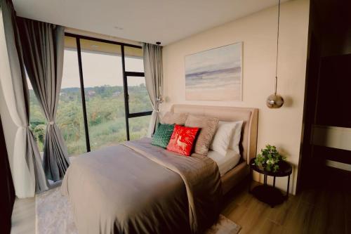a bedroom with a bed with a large window at Villa 360 in Calaca