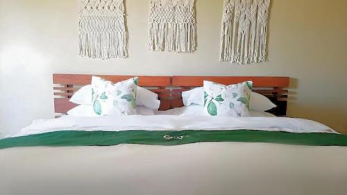 ein Schlafzimmer mit einem Bett mit weißen Laken und Kissen in der Unterkunft El Pueblo De Hermano by Cocotel in Lian