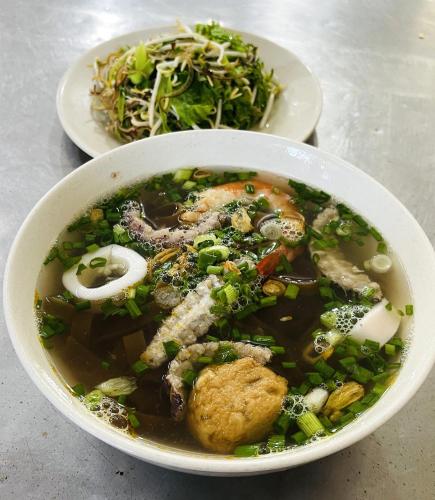 un tazón de sopa y un plato de ensalada en Ruby Star Hotel Apartment, en Vung Tau