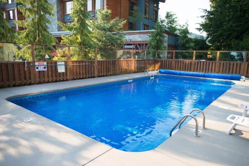a large blue swimming pool in front of a building at Creekside Oasis 4 Beds Pool and Hot Tub in Whistler