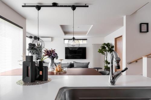 a kitchen with a sink and a living room at The Verite in Asahikawa