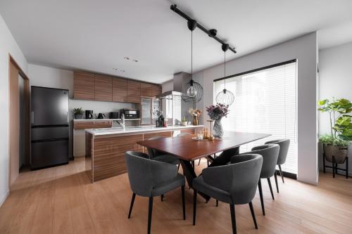 a kitchen and dining room with a wooden table and chairs at The Verite in Asahikawa