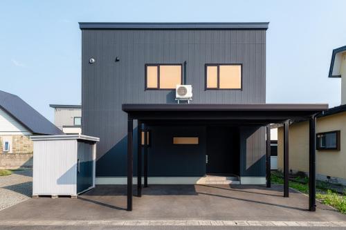 a black house with a chair on top of it at The Verite in Asahikawa