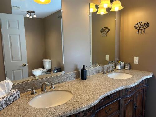 een badkamer met twee wastafels en een grote spiegel bij Rutledge Lake Retreat in Bancroft