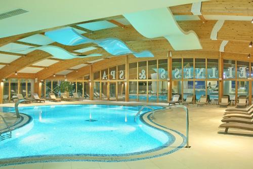 a large swimming pool with blue water in a building at Hotel Olimp in Zlatibor