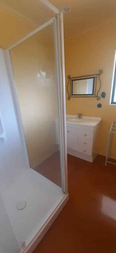a bathroom with a large mirror and a sink at Hosts on the Coast Titoki Palms in Matarangi