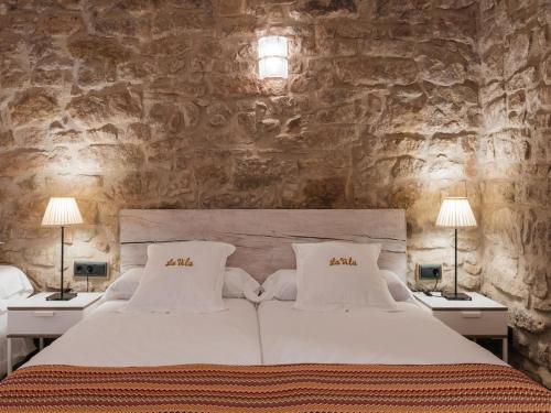 ein Schlafzimmer mit einem großen weißen Bett mit zwei Lampen in der Unterkunft Cottage in Castellnou with Forest Trails in Castellnou de Bages