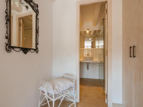 einen weißen Stuhl im Flur mit Spiegel in der Unterkunft Cottage in Castellnou with Forest Trails in Castellnou de Bages