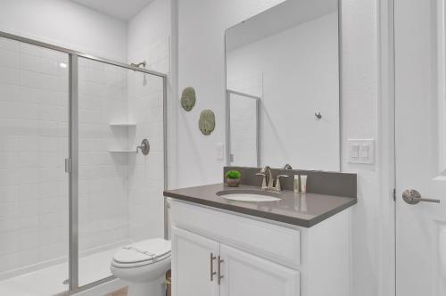 a bathroom with a toilet and a sink and a shower at 475 Strand Dr in Melbourne Beach