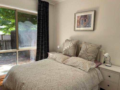 une chambre avec un lit et une grande fenêtre dans l'établissement Inner North Elegance Premier Turner Living 2 Bed, 2 Bath Townhome, à Turner