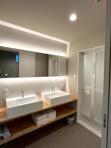 a bathroom with two sinks and a large mirror at Liaison Court Nishikujo Universal Bay 2 in Osaka