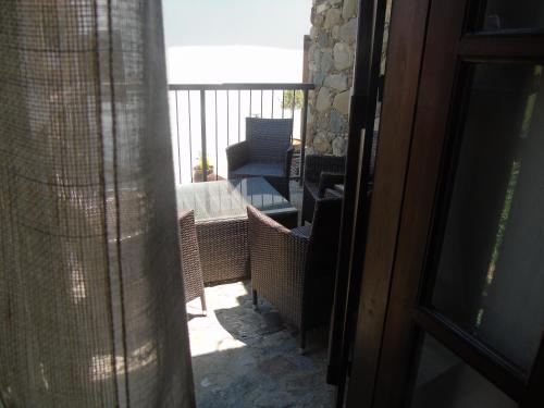 a balcony with a chair and a table and a window at Enipnion Apartments in Kakopetria